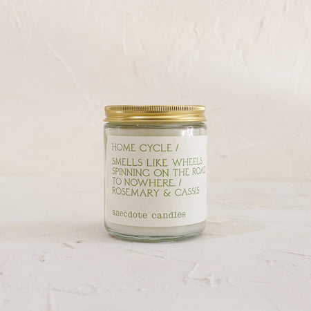 Glass candle with gold lid on textured background