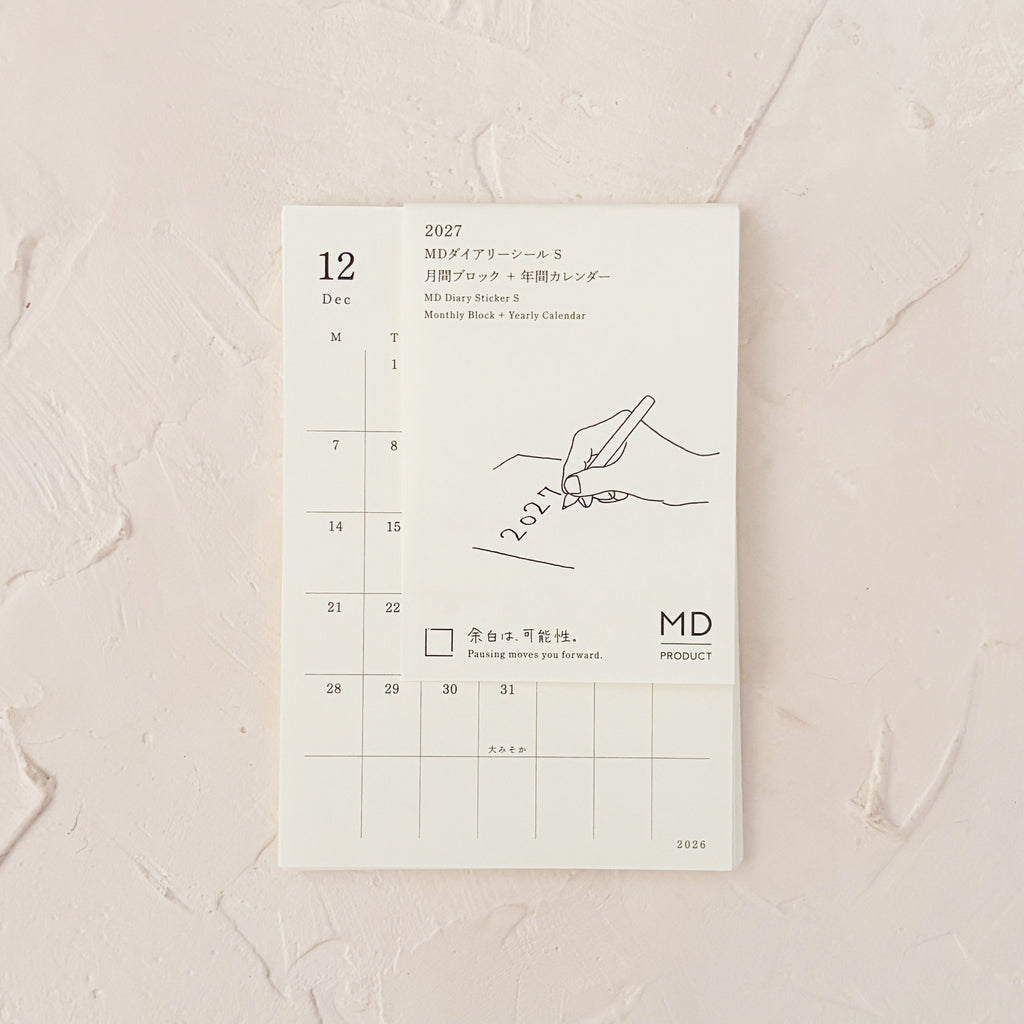 monthly calendar stickers in a stack on textured background