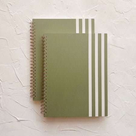 green notebook with white stripes on textured background