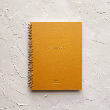 Orange notebook on textured background. 