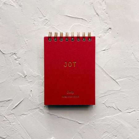 red jotter notebook on textured background