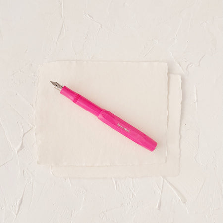 Hot pink fountain pen on textured paper