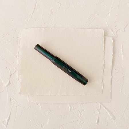 iridescent dark blue fountain pen on textured paper
