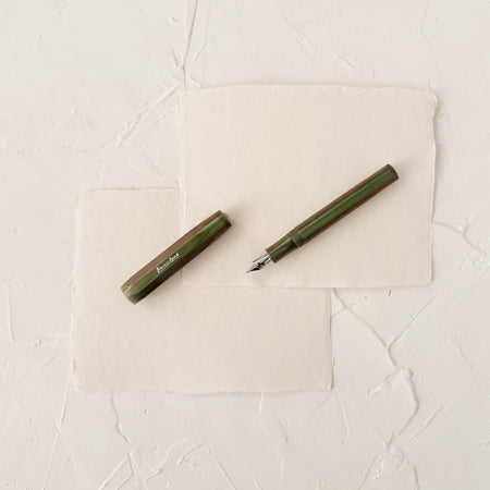 dark green pearl like fountain pen on textured paper