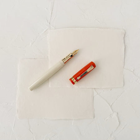 orange and cream fountain pen on textured paper