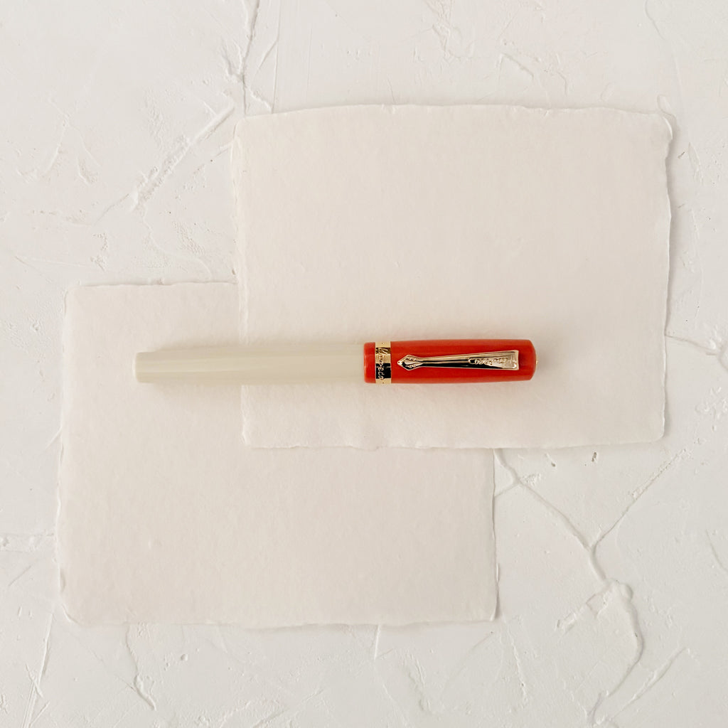 orange and cream fountain pen on textured paper