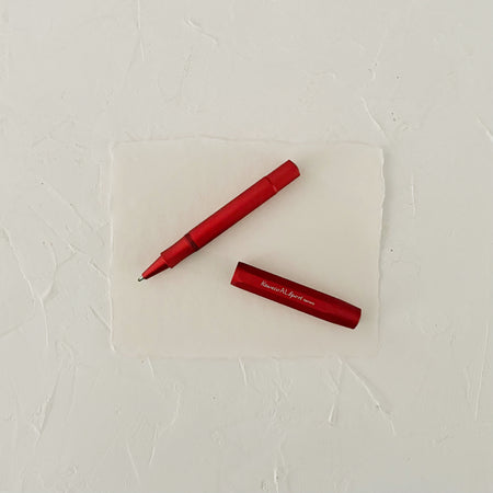 red metal rollerball on textured paper