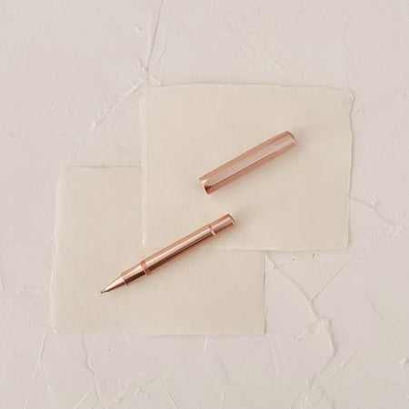 rose gold metal rollerball on textured paper