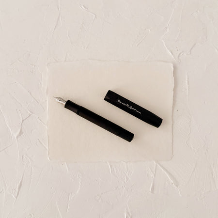 black metal fountain pen on textured paper