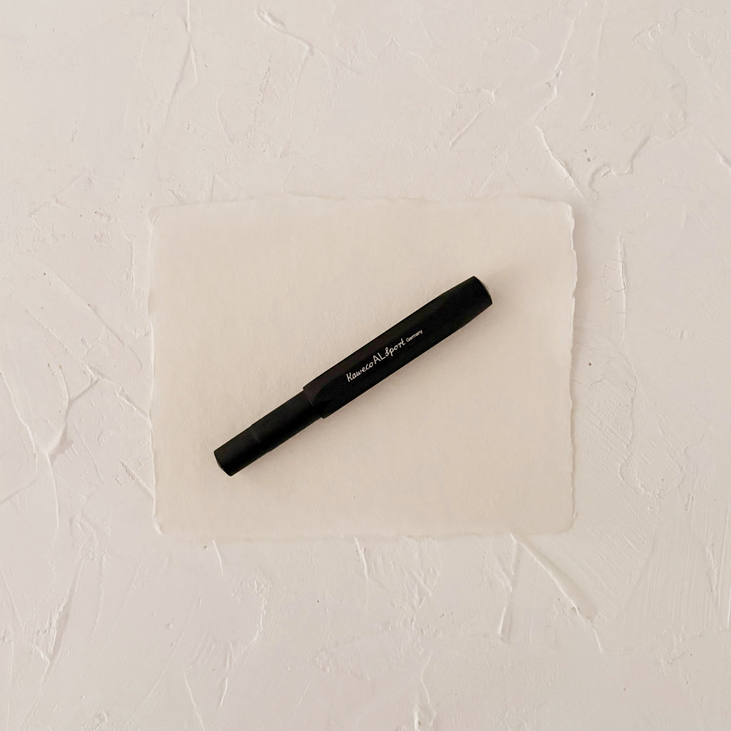 black metal fountain pen on textured paper