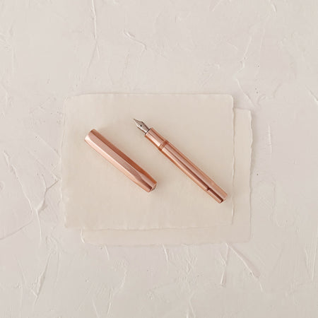 Rose gold fountain pen on textured paper
