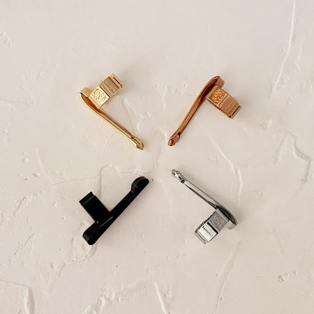 four kaweco pen clips - bronze, black, silver, gold.