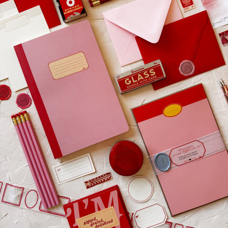 Stationery items including notebooks, envelopes, and stationery supplies on a light background