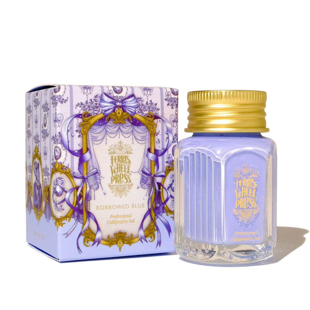 Square glass bottle with gold cover and gold text saying, "Ferris Wheel Press" with images of flowers on front of bottle. Ink is periwinkle blue. Packaged in square blue box with images of blue ribbons.