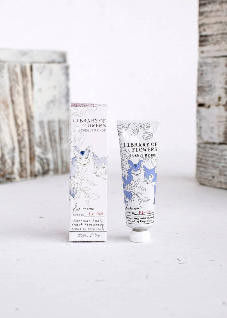 White box and white tube with images of gray and blue wolves. Black text saying, “Margot Elena Library of Flowers Forget Me Not Handcreme”.