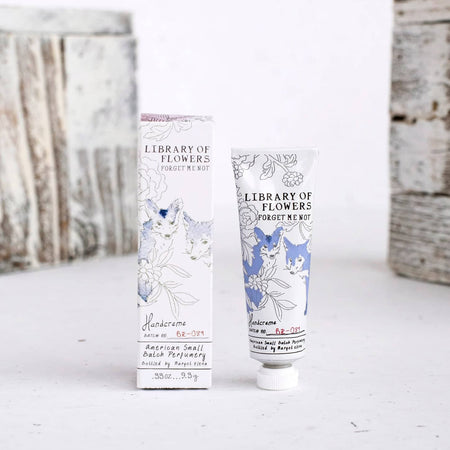 White box and white tube with images of gray and blue wolves. Black text saying, “Margot Elena Library of Flowers Forget Me Not Handcreme”.