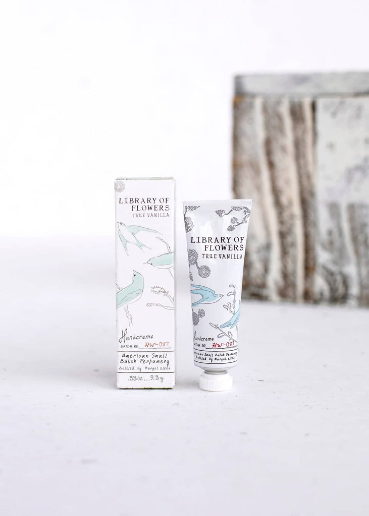 White box and white tube with images of bluebirds on a branch. Black text saying, “Margot Elena Library of Flowers True Vanilla Handcreme”.