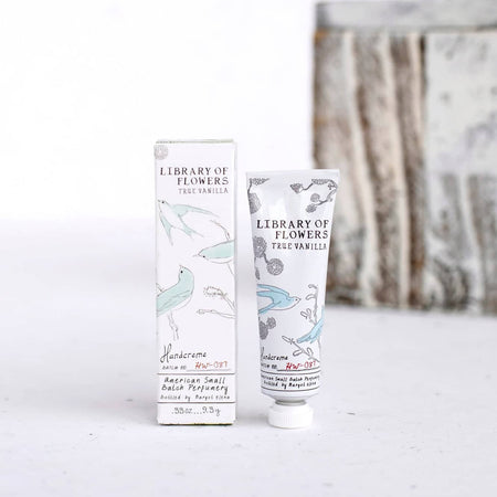 White box and white tube with images of bluebirds on a branch. Black text saying, “Margot Elena Library of Flowers True Vanilla Handcreme”.