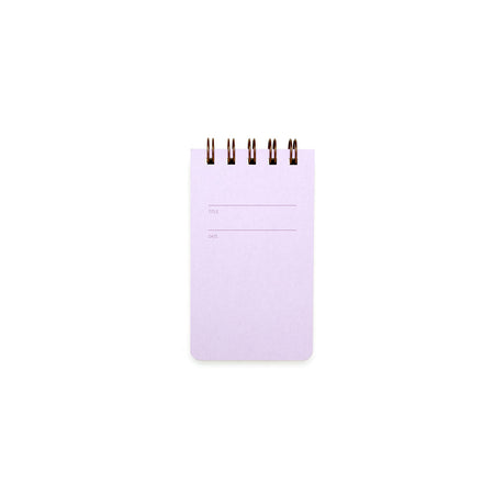 Lilac background with rectangular box in center with a place to title and date. Metal coil binding across the top. Inside has lined pages.