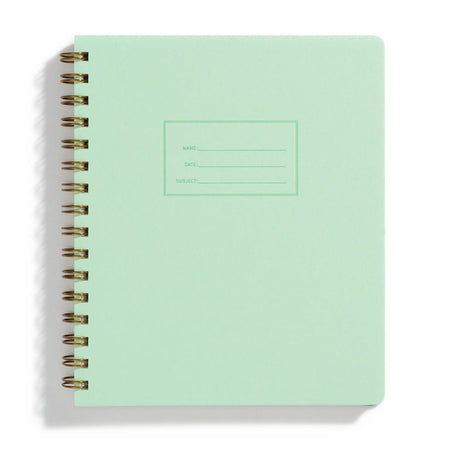 Mint green background with rectangular box in center with a place to write name, date and subject. Metal coil binding on left side.
