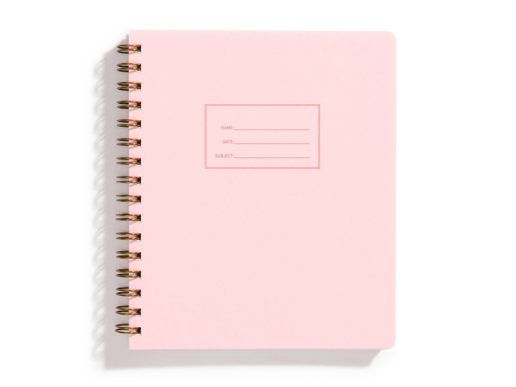 Pink background with rectangular box in center with a place to write name, date and subject. Metal coil binding on left side.   Inside has line pages.