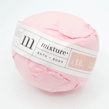 Circle ball wrapped in pink packaging with white and pink label. Black text saying, “Mixture Bath & Body Blanc de Noir”.