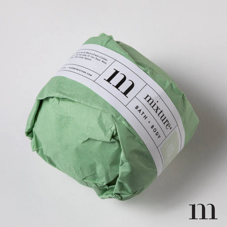 Circle ball wrapped in green packaging with white and green label. Black text saying, “Mixture Bath & Body Salt & Sage”.