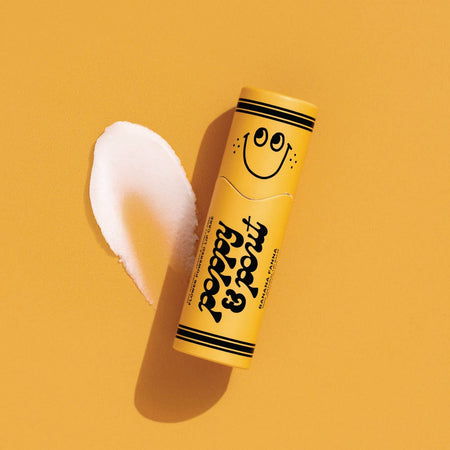 Small yellow tub with black text saying, “Poppy & Pout Banana Fanna”. Image of a smiley face on cap on top of tube. Black stripes on top and bottom of tube.