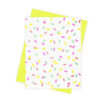 White card with pink, yellow, orange and green candy sprinkles scattered across card. A bright yellow envelope is included.
