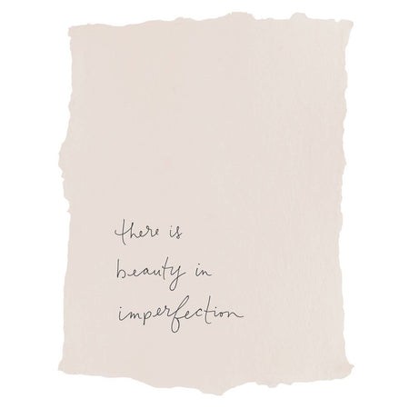 Art print blush rectangle with torn edges and black text saying, “There is Beauty in Imperfection”.