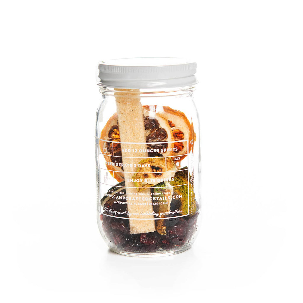 Cocktail jar with dried cranberries, tomatillos, limes and lemons.