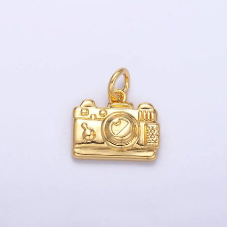 Gold charm in the image of a vintage camera.