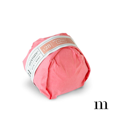 Circle ball wrapped in pink packaging with white and pink label. Black text saying, “Mixture Bath & Body Grapefruit & Sweet Vanilla”.