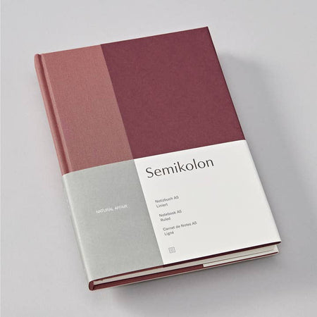 Hardcover journal with two toned pink cover. Lighter pink strip on left side.