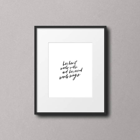 Art print on white background with black text saying, “Her heart wants roots but her mind wants wings.” 
