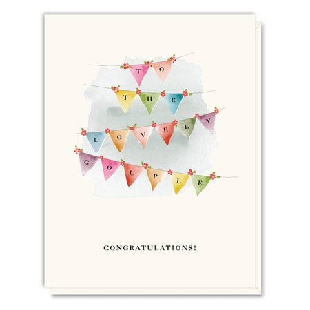 White card with images of colorful pendant flags with black letters spelling, “To The Lovely Couple”. Black text saying, “Congratulations!” A white envelope is included.