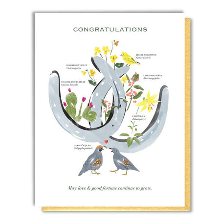 White card with image of a pair of silver horseshoes and different birds and flowers. Green text saying, “Congratulations”.  A gold envelope is included.