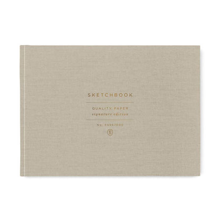 Gray linen notebook with gold foil text saying, “Sketchbook Quality Paper Signature Edition”.