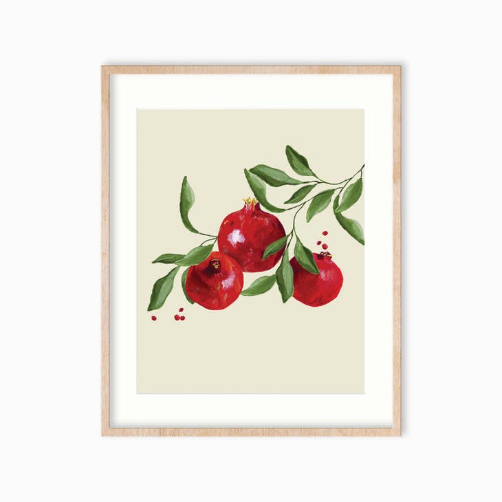 Art print with tan background with red pomogranate fruits attached to green leaves.