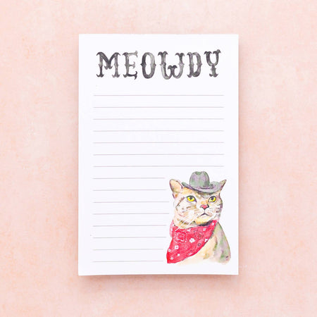 White lined notepad with image of a cat dressed as a cowboy wearing a hat and red bandana. Black western style text saying, “Meowdy” across top center.