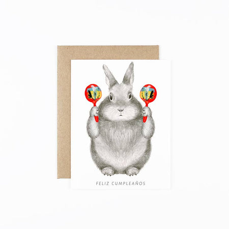 White card with image of a gray bunny playing the maracas with black text that reads 