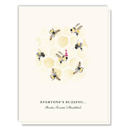 White card with images of bees on a honeycomb. One bee is wearing a birthday party hat. Black text saying, “Everyone’s Buzzing..” A white envelope is included.