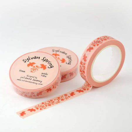 Pink washi tape with repeating images of red flowers and red birds.