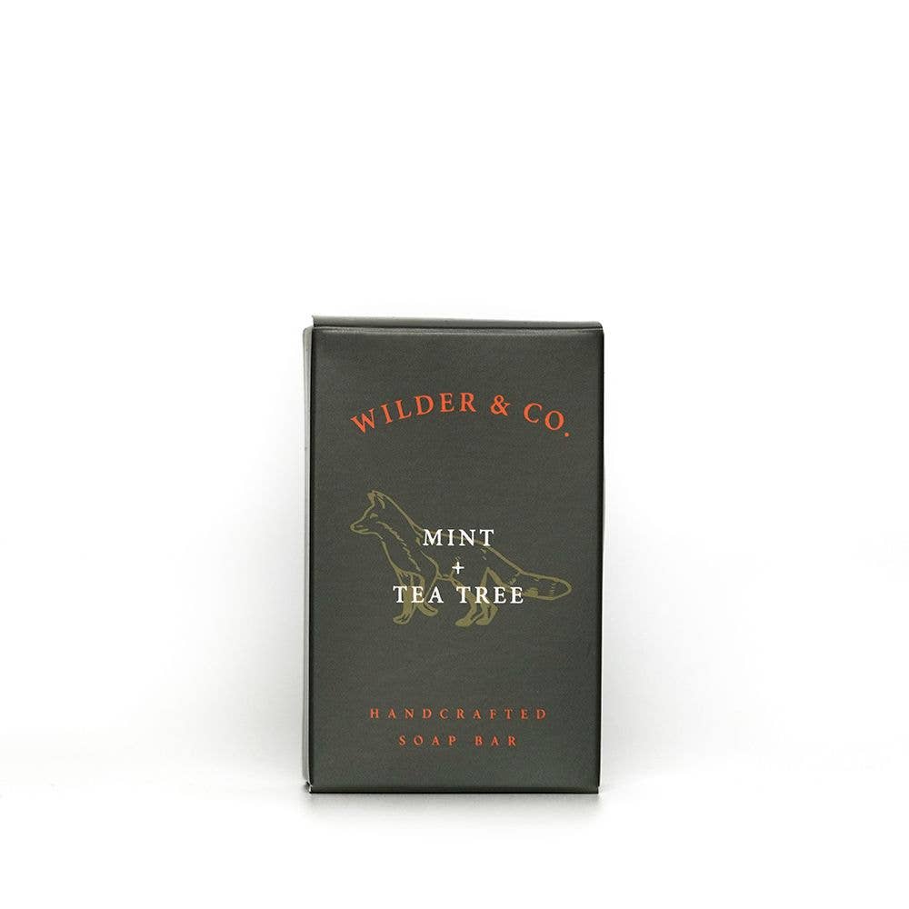 Small black box with red text saying, “Wilder & Co. Handcrafted Soap Bar Mint & Tea Tree”. Image of a gold fox in center. 