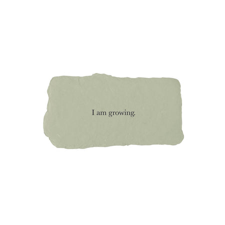 Green rectangle with torn edges and black text saying, “I am Growing”.