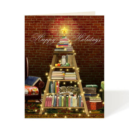 Greeting card with a ladder bookshelf, books, and a small tree against a brick wall with white text saying, “Happy Holidays”. A white envelope is included.