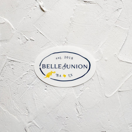 oval belle & union sticker with navy text and a yellow texas and armadillo icon.
