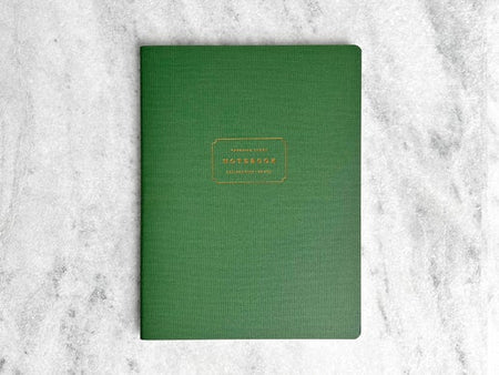 Notebook with green cover with gold text box in center with gold foil text saying, “Favorite Story Notebook”.