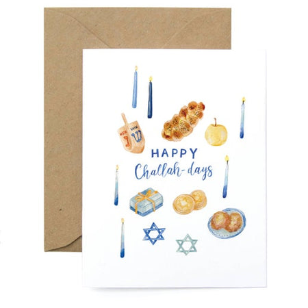 White card with blue text saying, “Happy Challah-days”. Images of Hanukkah items such as: blue candles, dredals, challah bread, and Star of David. A kraft envelope is included.