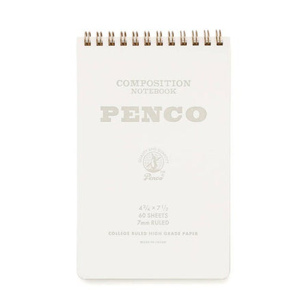 White notebook with gray text saying, “Composition Notebook PENCO”. Gold coil binding across top of notebook.